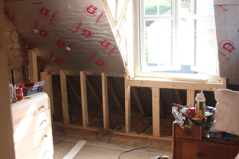 Loft conversion in progress with insulation and timber framing