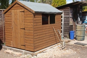 Photo of a typical garden shed with a felt roof stained in wood preserver.